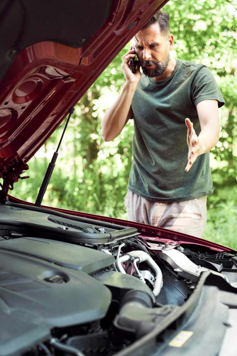 Junger Mann prüft Getriebeschaden bei Schrottauto Ankauf Bramsche